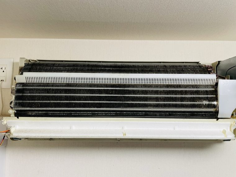 クリーニング前のエアコン内部。熱交換器にホコリが詰まっている状態