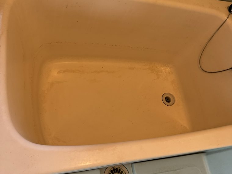 クリーニング前の浴槽。水垢と皮脂汚れでくすんだ状態
